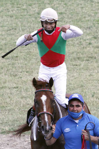 jockey festejando haber ganado la carrera de caballos gran premio pellegrini